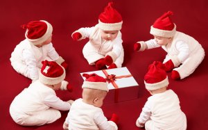 Малыши в новогодних шапках с подарком - скачать обои на рабочий стол