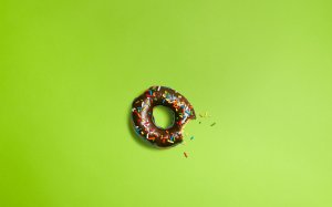 Шоколадный пончик на зеленом фоне - скачать обои на рабочий стол