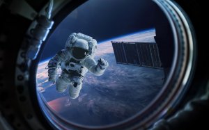 Астронавт в иллюминаторе в космосе - скачать обои на рабочий стол